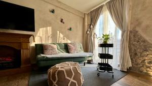 a living room with a green couch and a fireplace at Loft Giofiel in Santeagueda