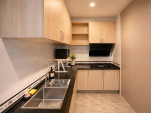 a kitchen with wooden cabinets and a sink at Holi PTY Hotel in Ban Huai Yai