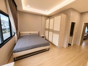 a bedroom with a bed and a large window at Holi PTY Hotel in Ban Huai Yai +4 photos