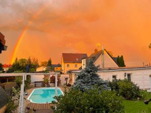 a rainbow over a house with a pool at Haus am Pool in Knautkleeberg