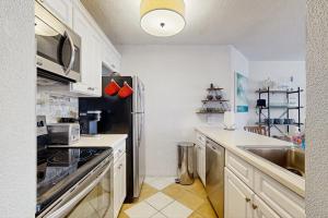 a kitchen with white cabinets and a stainless steel refrigerator at Pyramid 8K in Ocean City +10 photos