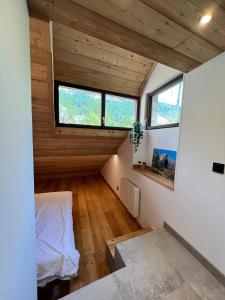 a room with a bed and two windows at Appartement moderne style chalet in Le Monêtier-les-Bains