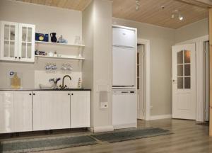 a kitchen with white cabinets and a refrigerator at Paju Apartment in Võru