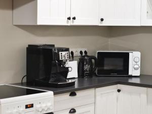 a kitchen with a coffee maker and a microwave at Paju Apartment in Võru +2 photos