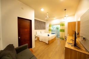 a bedroom with a bed and a couch in a room at Villa Crescenta in Ukulhas