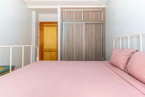 a bedroom with a bed with a pink pillow on it at Al manar in Oulad Akkou