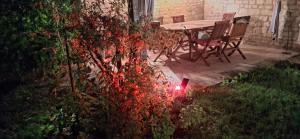 a table and chairs in a garden with red lights at Lacelledort in La Celle-Saint-Avant