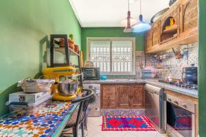 a kitchen with green walls and a counter top at Al manar in Oulad Akkou