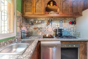 a kitchen with a sink and a stove at Al manar in Oulad Akkou +14 photos