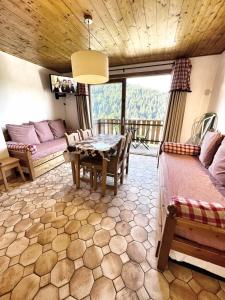 a living room with a table and a couch at Studio Croix Viallet, Chez Francine in Notre-Dame-de-Bellecombe