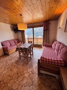 a living room with a bed and a table at Studio Croix Viallet, Chez Francine in Notre-Dame-de-Bellecombe