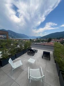 a patio with chairs and tables on a roof at Lake & More Suite Hotel in Paratico