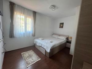 a small bedroom with a bed and a window at Colț de Vâlsan in Brăduleţ