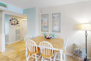 a dining room with a wooden table and chairs at Antigua 1004 in Ocean City +20 photos