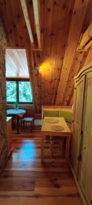 a room with a table and a bench in a cabin at Cztery Pory Lasu in Silna Nowa
