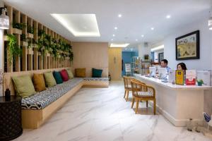 a restaurant with a long couch in a room at Costa Village Jacuzzi Bangsaray in Bang Sare