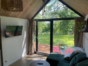 a living room with a couch and a large glass door at RiverHouse in Bałtów