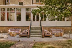 a group of chairs and tables in front of a building at Ember Locke Kensington in London