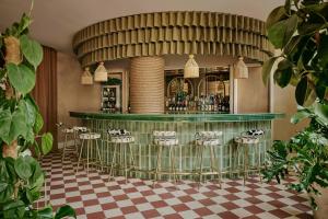 a restaurant with a bar with stools at Ember Locke Kensington in London