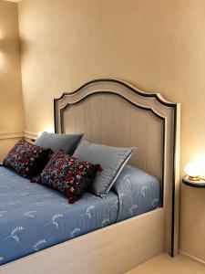 a bed with blue sheets and pillows on it at Castello di Morozzo Guest House in Morozzo