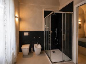 a bathroom with a toilet and a glass shower at Castello di Morozzo Guest House in Morozzo