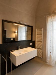 a bathroom with a white sink and a mirror at Castello di Morozzo Guest House in Morozzo