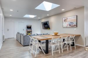 a dining room with a table and a couch at Loft pour 14 personnes in Saint-Étienne-du-Rouvray