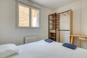 a bedroom with a bed and a refrigerator and a window at Loft pour 14 personnes in Saint-Étienne-du-Rouvray