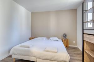 a bedroom with a white bed with two pillows at Loft pour 14 personnes in Saint-Étienne-du-Rouvray +14 photos