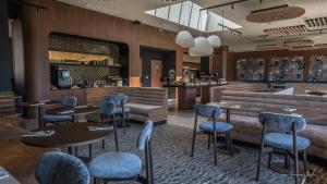 a restaurant with tables and chairs and a bar at Best Western Plus Metz Technopole in Metz