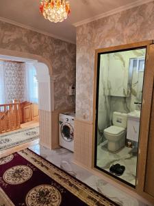 a bathroom with a toilet and a washing machine at Qecresh Garden House in Qǝçrǝş