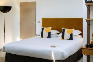 a bedroom with a large white bed with pillows at Best Western Hotel le Galice Aix-en-Provence in Aix-en-Provence
