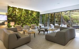 a living room with furniture and a large wall of windows at BW Premier Collection Le Saint Antoine Hotel et Spa in Rennes