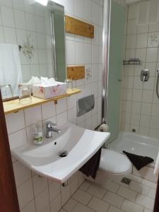 a bathroom with a sink and a toilet and a tub at Pension Chapeau-Claque in Cochem