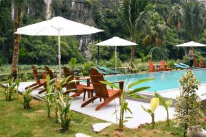 a group of chairs and umbrellas next to a pool at Tam Coc Aurora Valley in Vũ Lâm