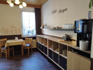a dining room with a table and a counter with a table and chairs at Pension Chapeau-Claque in Cochem