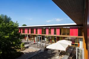an external view of a building with tables and umbrellas at DJH Jugendherberge Xanten in Xanten +13 photos