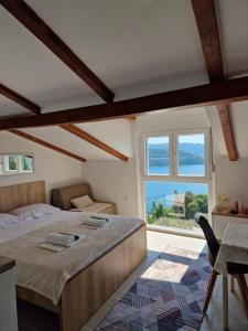 a bedroom with a large bed and a window at Apartmani Mandić in Neum