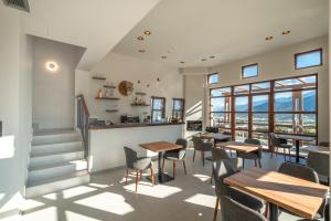a restaurant with tables and chairs and windows at Terra Petra Meteora in Kalabaka