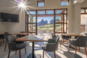 a room with tables and chairs and a large window at Terra Petra Meteora in Kalabaka