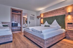 a bedroom with two beds and a wooden wall at Annies Bergwelt Haus Waldliebe in Bodenmais