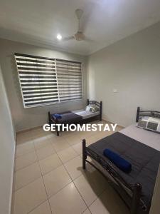 a bedroom with two beds and a window at Gethomestay Keningau in Keningau