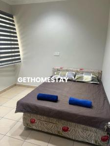 a bedroom with a bed with two blue pillows at Gethomestay Keningau in Keningau