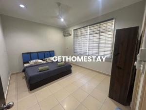a bedroom with a blue bed and a window at Gethomestay Keningau in Keningau