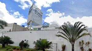 a tall building with a palm tree in front of it at Altana Motel in Brasília