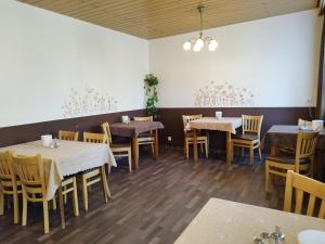 a restaurant with tables and chairs in a room at Pension Chapeau-Claque in Cochem