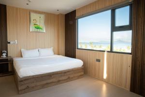 a bedroom with a bed with a large window at Alphan Hotel in Vạn Ninh