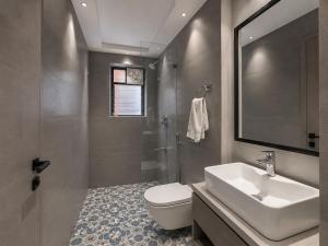 a bathroom with a sink and a toilet and a shower at The Bay Suites - MMR in New Town