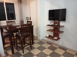 a living room with a table and a television at Les Vavangues in Saint-Leu
