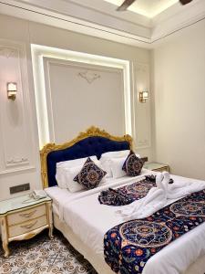 a bedroom with a king sized bed with a blue headboard at Hotel The Raghavas' in Ayodhya